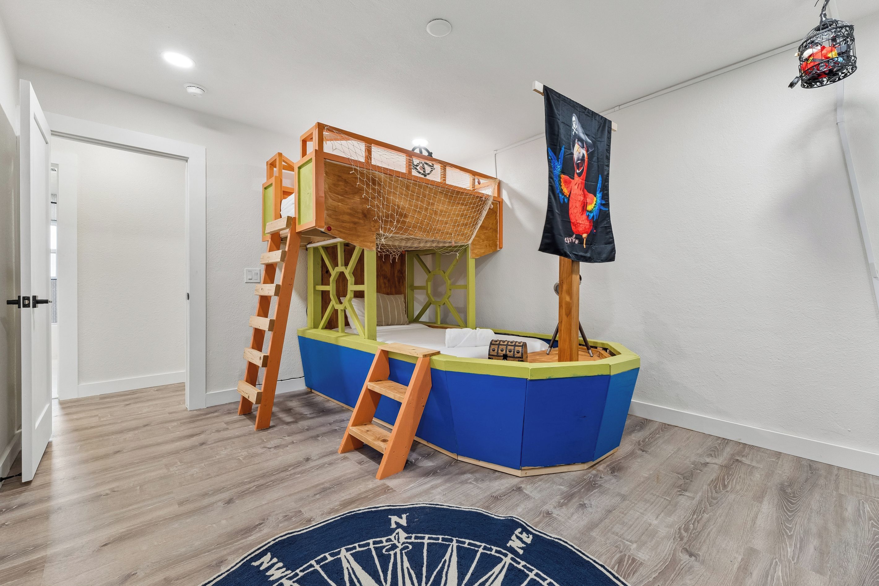 Spielbereich für Kinder mit Stockbett, einer Kletterleiter und einer Piratenflagge.