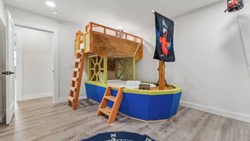 Spielbereich für Kinder mit Stockbett, einer Kletterleiter und einer Piratenflagge.