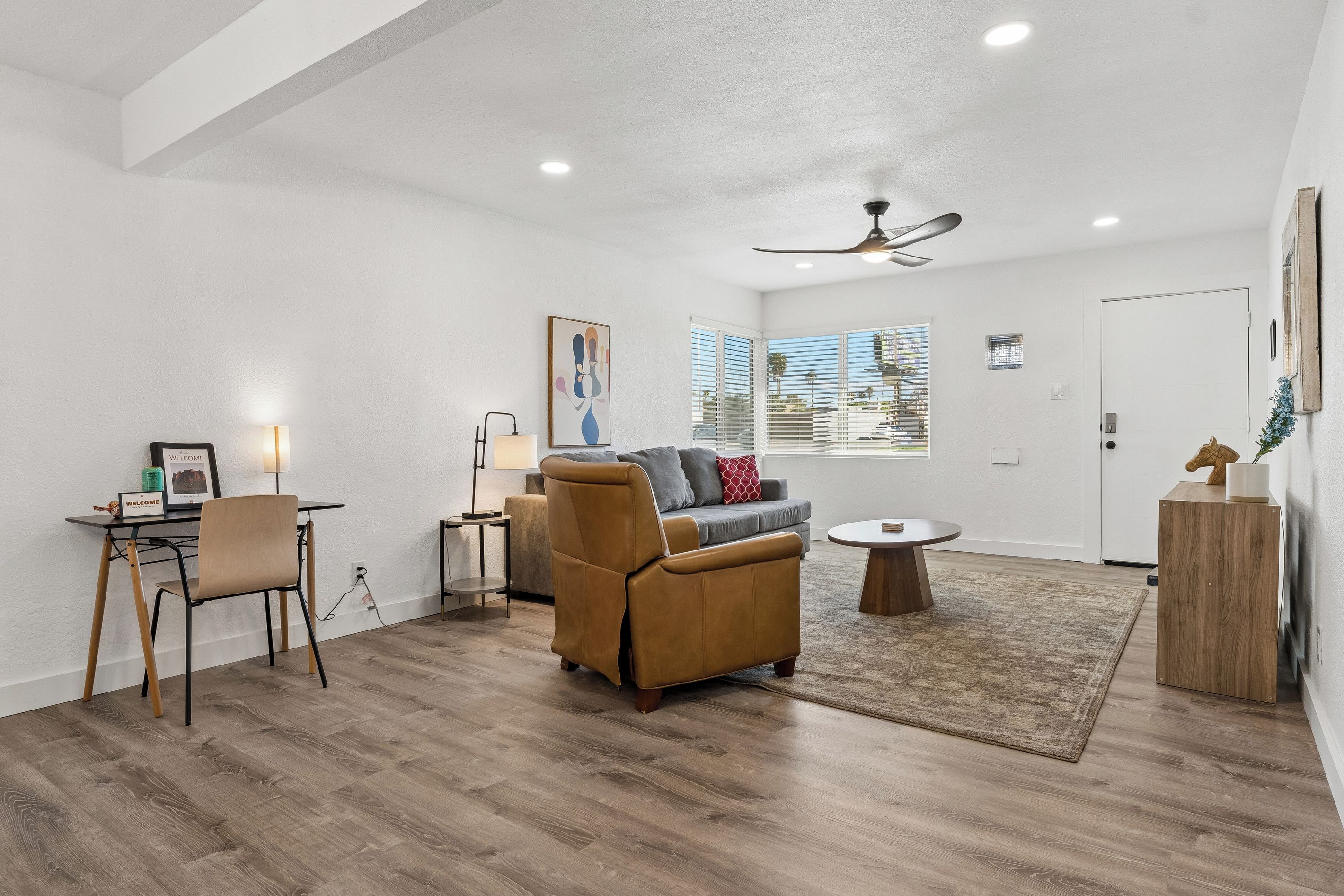 A modern living room with a sofa, a coffee table, and a dining area with a table and chairs.