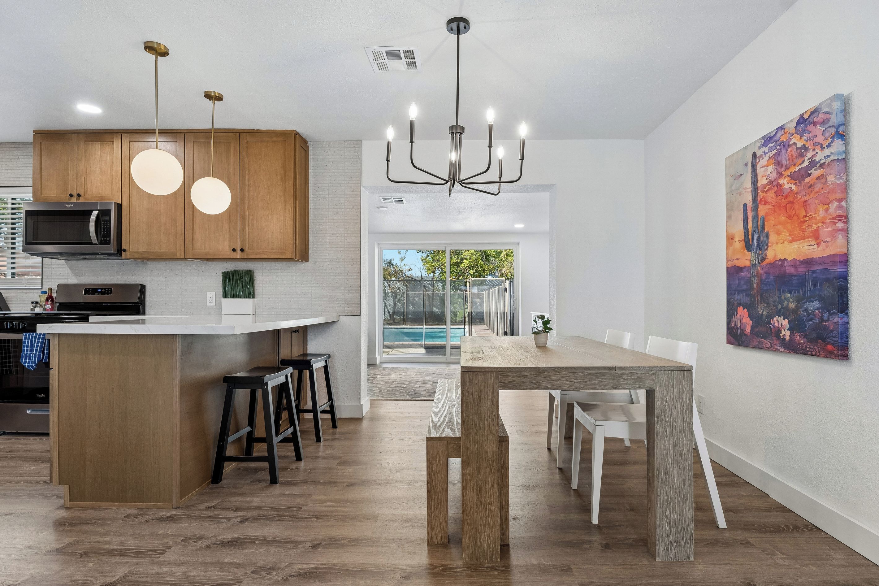 Eine moderne Küche mit Holzausstattung, einer eingebauten Mikrowelle und einer Bar mit Hockern.