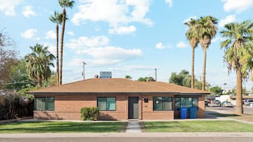 A single-story brick building with a flat roof, a small front porch, and a clear sky.