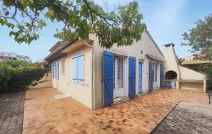 A two-story house with a tiled patio, blue shutters, and a chimney. - Beautiful home in Valras Plage with WiFi (Valras Plage)