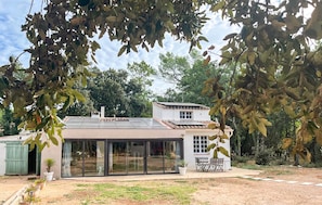 A modern house with a large glass door entrance, a tiled roof, and a garden area with potted plants. - Nice home in Le Val with private swimming pool, can be inside or outside (Le Val)