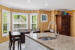 A kitchen with a granite countertop, a sink, and wooden paneling. - Arrowhead Hideaway Hot Tub Fire Pit Game Room (Monroe County)