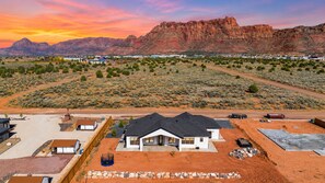 A residential area with a house in the foreground and a mountain range in the background. - Modern 3BR Home with Fenced Yard Near Zion & Dunes (Colorado City)