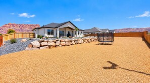 A residential property with a house, a fenced yard, and a clear view of a mountainous landscape. - Modern 3BR Home with Fenced Yard Near Zion & Dunes (Colorado City)