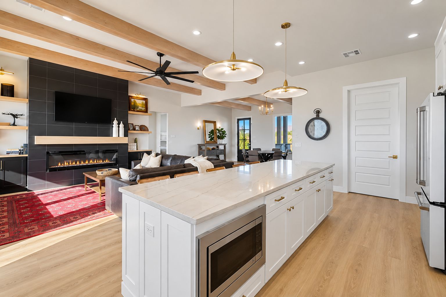A modern kitchen with a central island, built-in oven, and a fireplace.