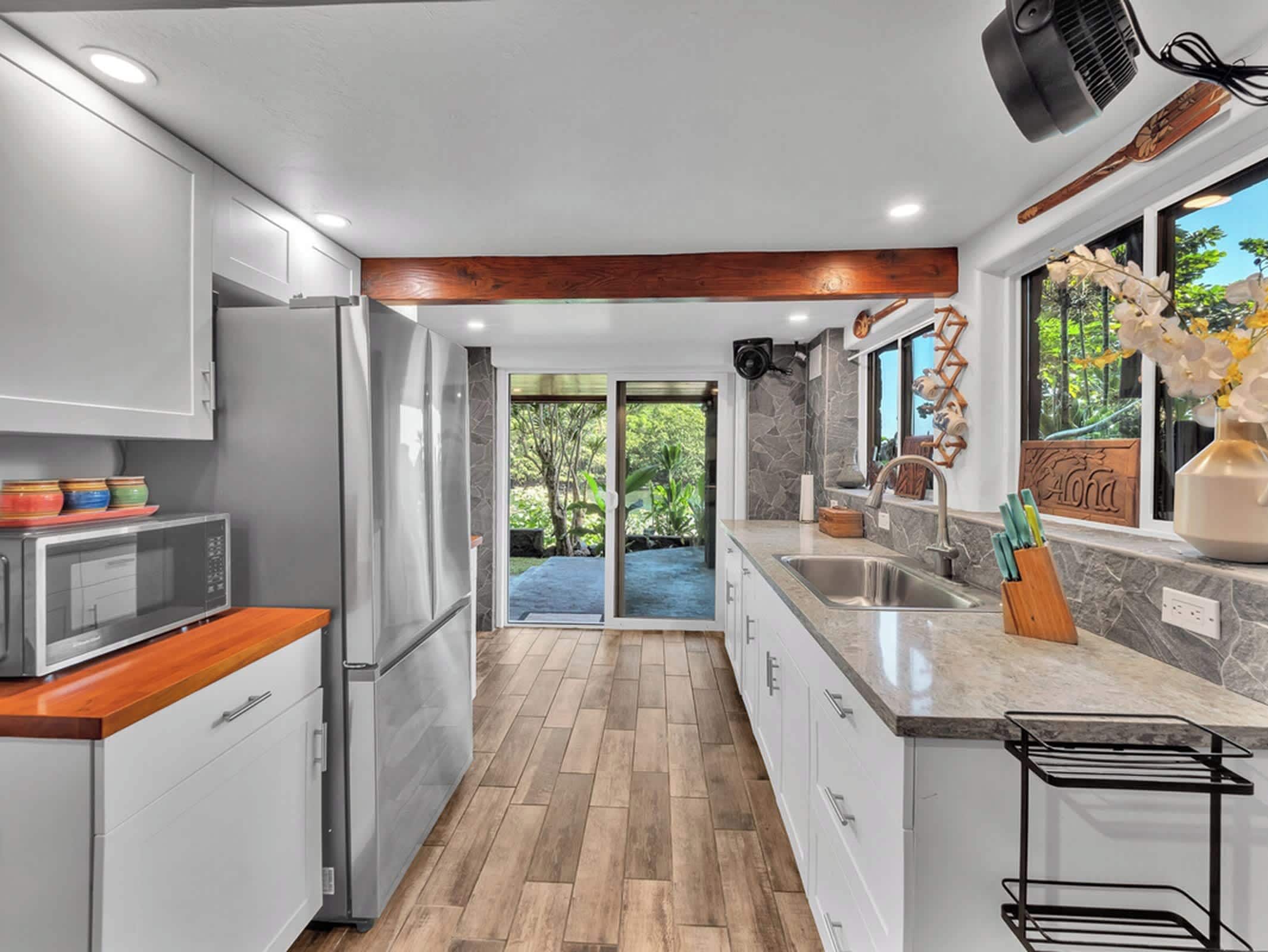 A modern kitchen with a built-in refrigerator, a microwave, and a sink.