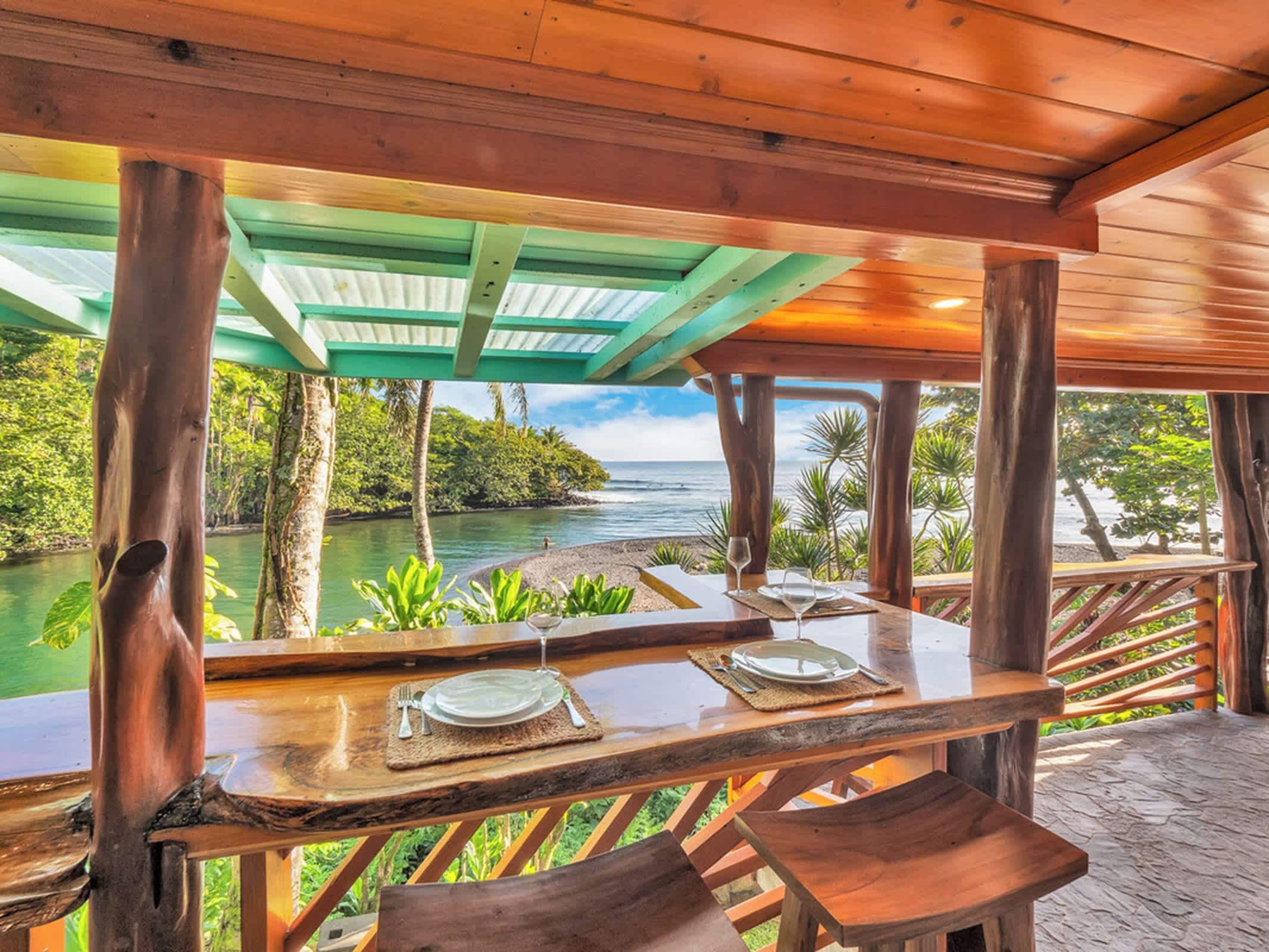 Un área de comedor al aire libre con vistas a un río y vegetación.