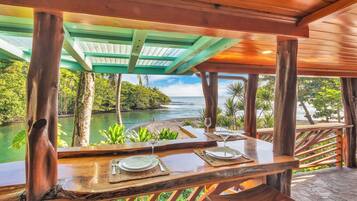 Un área de comedor al aire libre con vistas a un río y vegetación.