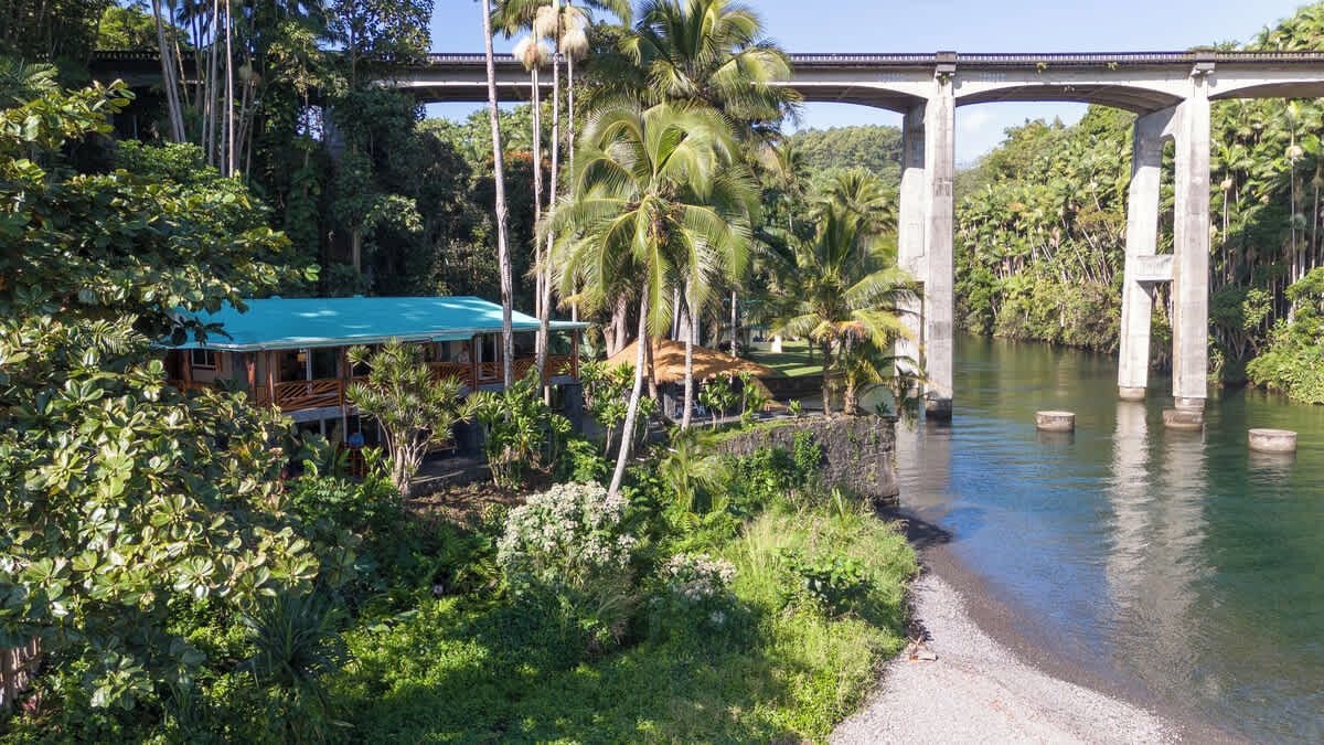 A bridge over a river with a building on the left.