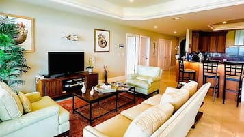 A spacious living room with a sofa set, a coffee table, and a television.