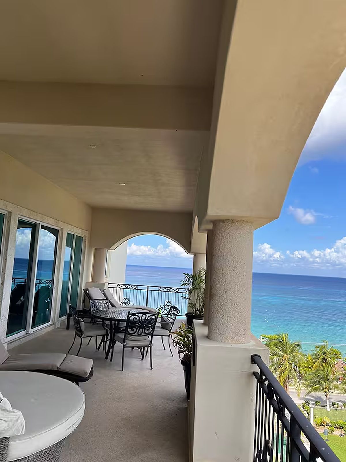 Ein Balkon mit Meerblick, ausgestattet mit einem Tisch, Stühlen und einer runden Sitzecke.