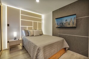 Un dormitorio moderno con cama, mesita de noche y un cuadro de la ciudad en la pared.