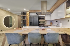 A modern kitchen with a central island, built-in appliances, and a wooden ceiling. - Brand New Cozy Gem & Luxury Living with AC (Medellín)