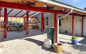 An outdoor patio with a covered seating area, a trash bin, and a potted plant. - 3 bedroom pet friendly home in Bandholm (Bandholm)