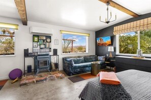 A cozy bedroom with a large bed, a fireplace, and a view of the outdoors.