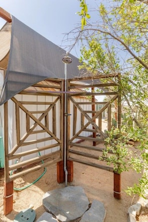 A wooden gate structure with a metal gate, a shaded area, and a small plant. - Tubs, Romantic Views, Quiet, Stars-Serene Haven (Joshua Tree)