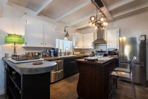 A modern kitchen with a central island, stainless steel appliances, and pendant lighting. - Cowboy Tubs, Quiet, Zen, Stars-1 bd + Studio (Joshua Tree)