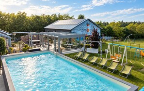A swimming pool with a sunshade structure, lounge chairs, and a children's play area. - Gorgeous home in Sarbinowo with private swimming pool, can be inside or outside (Sarbinowo)