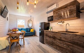 Eine kleine Küche mit Kühlschrank, Mikrowelle und Holzschränken.