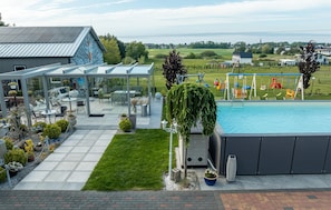 Ein Wohngebiet mit Schwimmbad, Sitzgelegenheiten im Freien und Blick auf eine Stadt.