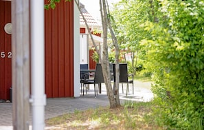 A red building with the number 52, a paved walkway, and outdoor seating with chairs and tables. - Amazing home in Varberg with heated swimming pool (Varberg)