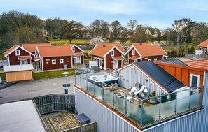 Ein Wohngebiet mit mehreren Häusern mit roten Dächern, einem glasüberdachten Whirlpoolbereich und freiem Blick auf die umliegende Nachbarschaft.