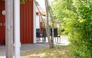 A red building with the number 52, a paved walkway, and outdoor seating with chairs and tables. - Beautiful home in Varberg with heated swimming pool (Varberg)