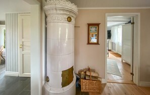 A hallway with a white column, a framed picture on the wall, and a wicker basket on the floor. - Stunning home in Mysinge with WiFi (Mysinge)