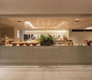 Een modern interieur met een marmeren aanrecht, potplanten en een eethoek.