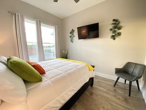 A bedroom with a bed, a chair, a TV, and a window with curtains. - Downtown Chattanooga Condo Overlooking Brewery (Chattanooga)