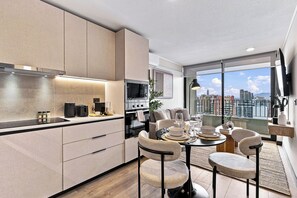 A modern kitchen with a dining area, large windows, and a city view. - Modern 2BR in Santiago - A/C • Parking • Great Location (Santiago)