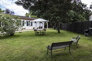 A backyard with a patio table, chairs, a bench, a swing set, and a barbecue grill. - Domaine du Vertbois - PIBRAC (PIBRAC)