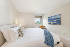 Ein Schlafzimmer mit Bett, Fenster und einem Bild an der Wand.