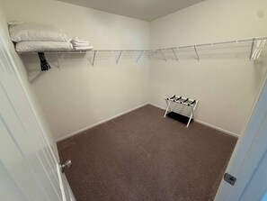 A room with a carpeted floor, a metal drying rack, and a small table with a shelf. - Large groups l Family gathering l MCR l RMNP (Loveland)