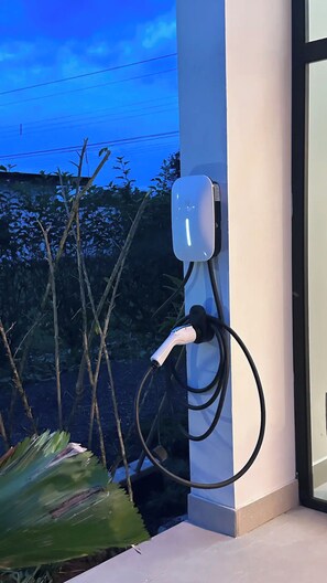 An electric vehicle charging station mounted on a wall with a clear sky in the background. - Legado 1905 - Sapphire and Diamond House (La Perla)