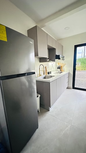 A modern kitchen with a stainless steel refrigerator, a built-in oven, and a sink. - Legado 1905 - Sapphire and Diamond House (La Perla)