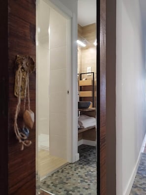 Acceso al baño privado desde la zona de descanso, con toallas de algodón