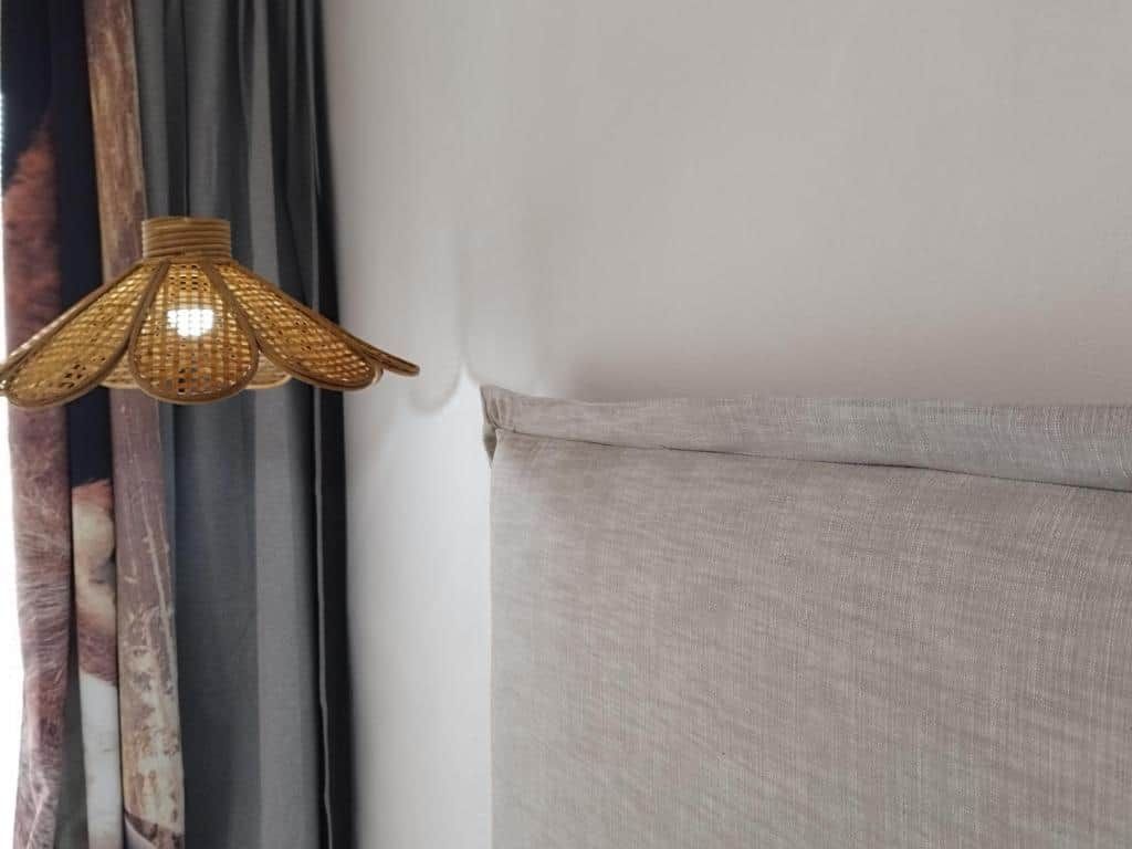 A room with a light fixture and a curtain.