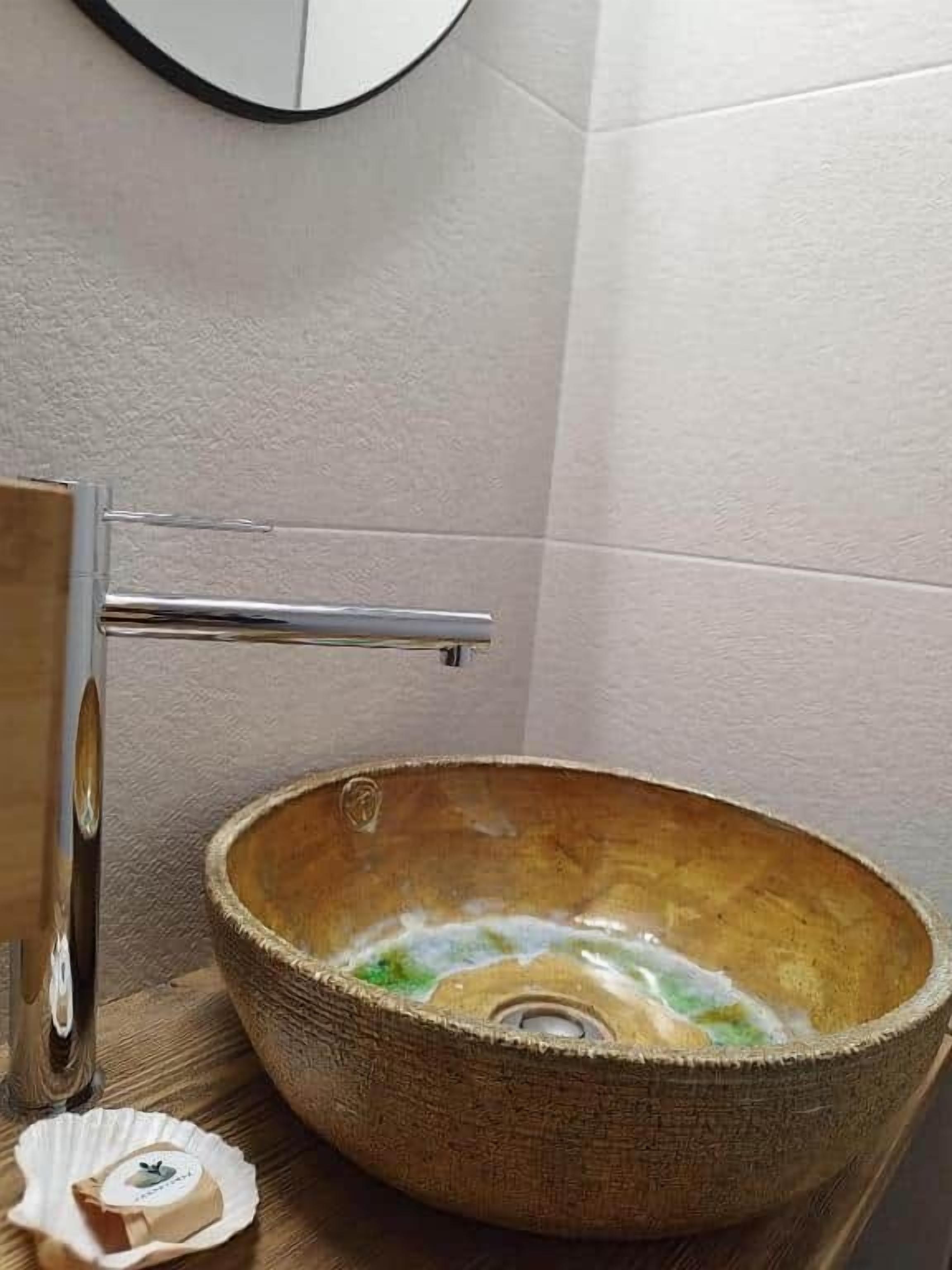 Ein Badezimmer mit einem Waschbecken aus Holz, einem chromfarbenen Wasserhahn und einer kleinen Seifenschale.