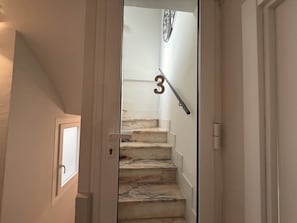 A staircase with a handrail and a number 3 sign above it.