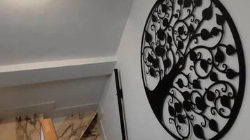 A staircase with a wooden handrail and a wall-mounted decorative metal piece.