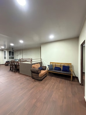 Un amplio espacio de sala con un sofá, una mesa de comedor y un ventilador de techo.