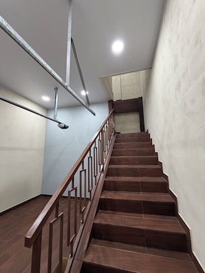 Una escalera con barandillas de madera y estructura de soporte metálica.