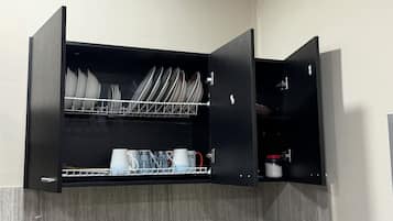 Una cucina con scolapiatti, macchina da caffè e una tazza a tema natalizio.