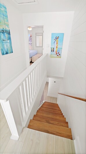 A staircase with white railings and wooden steps leading to a bedroom with a bed and a window. - 12B - 2BR $700+ in freebies incl golf, On Beach (Miramar Beach)
