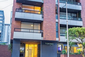 A multi-story building with a brick facade, balconies, and a visible entrance labeled 'TORINO E9-75'. - Wonderful 2-bedroom apartment in the heart of Quito (Quito)