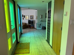 A hallway with a television, framed pictures, and a sofa in the background. - Modern beauty in Oak Bay, BC, Canada with ocean view and close to beach access (Oak Bay)