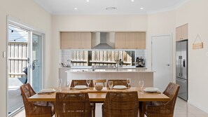 Well-lit dining space setup with a wooden table surrounded by chairs.    - Catherine Hill Bay - Ocean Views & Coastal Living (Catherine Hill Bay)